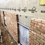 Slicker® MAX installed on a wall with brick siding