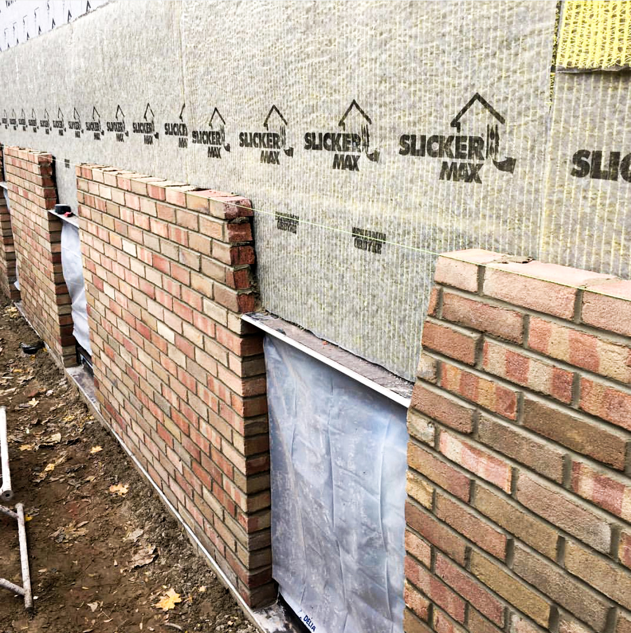 Slicker® MAX installed on a wall with brick siding